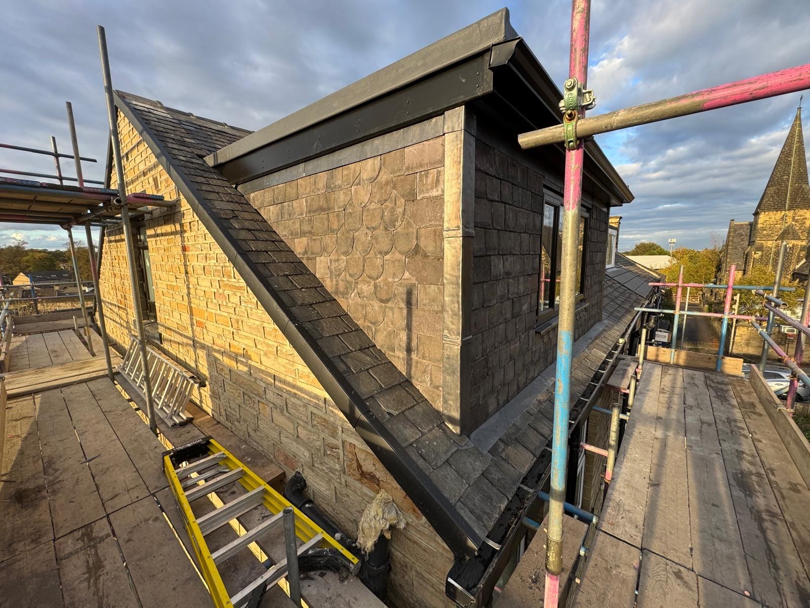 Dormer cheek with slate cladding and leadwork beside the slate roof in Pudsey