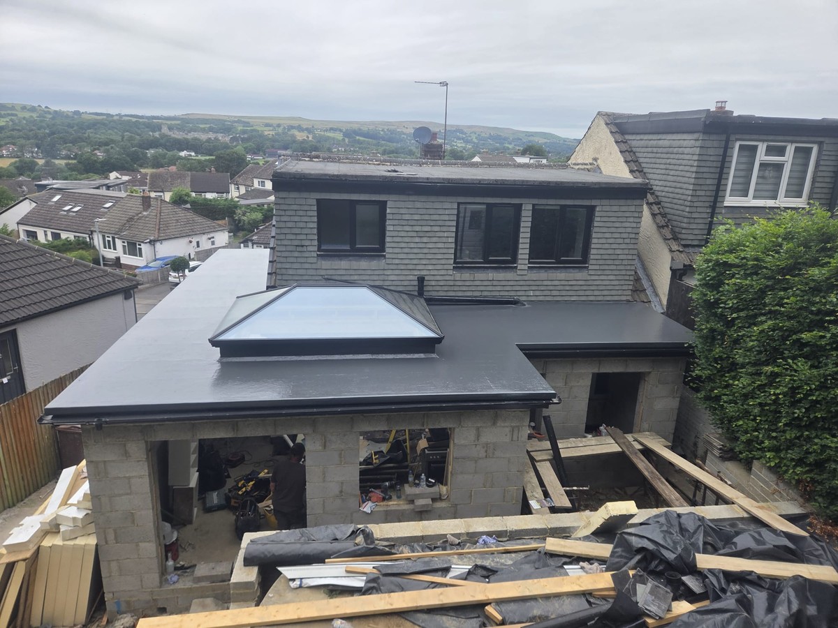 Dark flat extension roof with a glazed roof lantern in front of a dormer